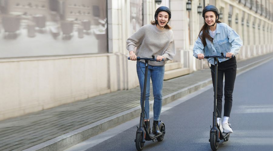 สกู๊ตเตอร์ไฟฟ้า Ninebot KickScooter F20A two women riding on street